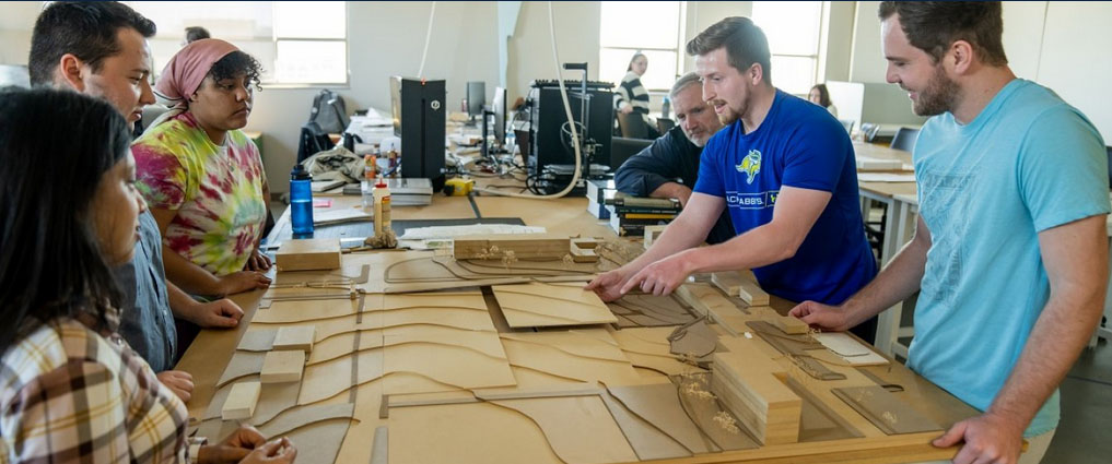 Students and instructor looking at a design project.