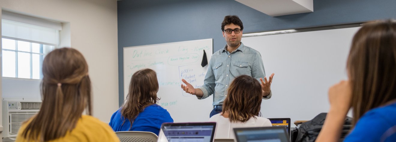 Instructor talking to a group of students in a classroom.