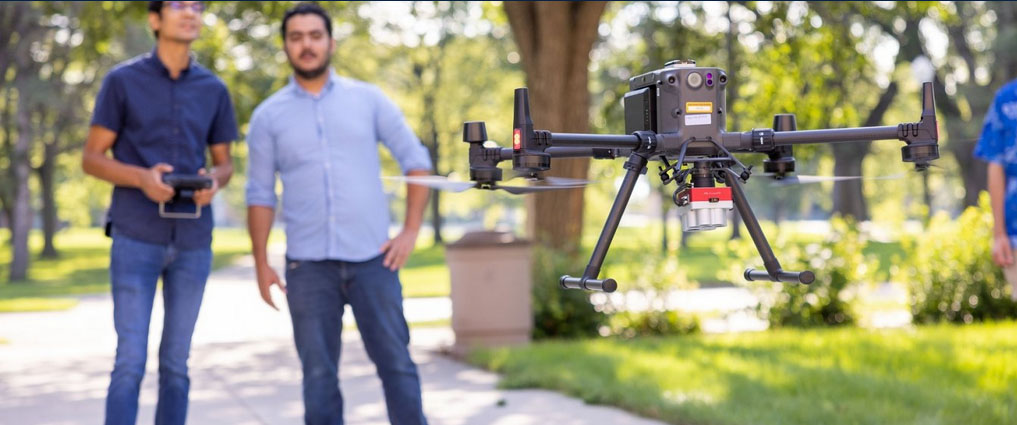 Student and faculty member flying a drone.