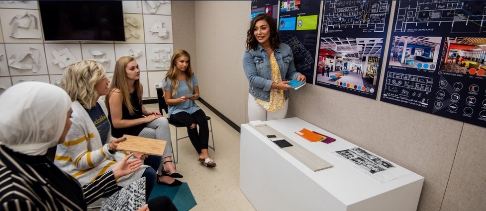 Students watch another student present in class.