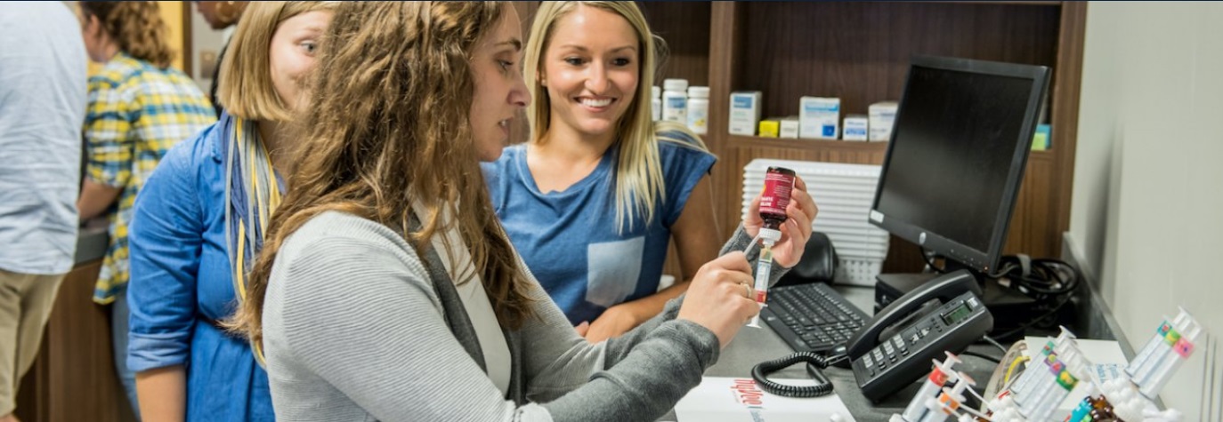 Students standing with a pharmacist.