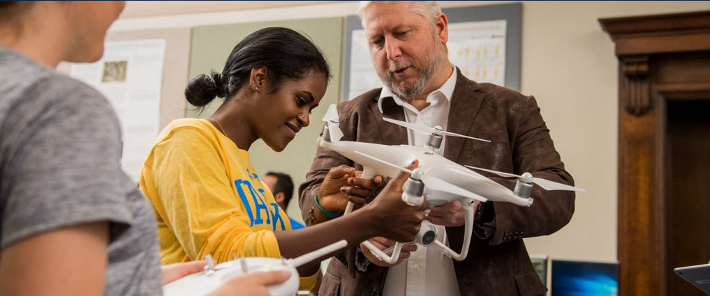 Students and instructor looking at a drone.