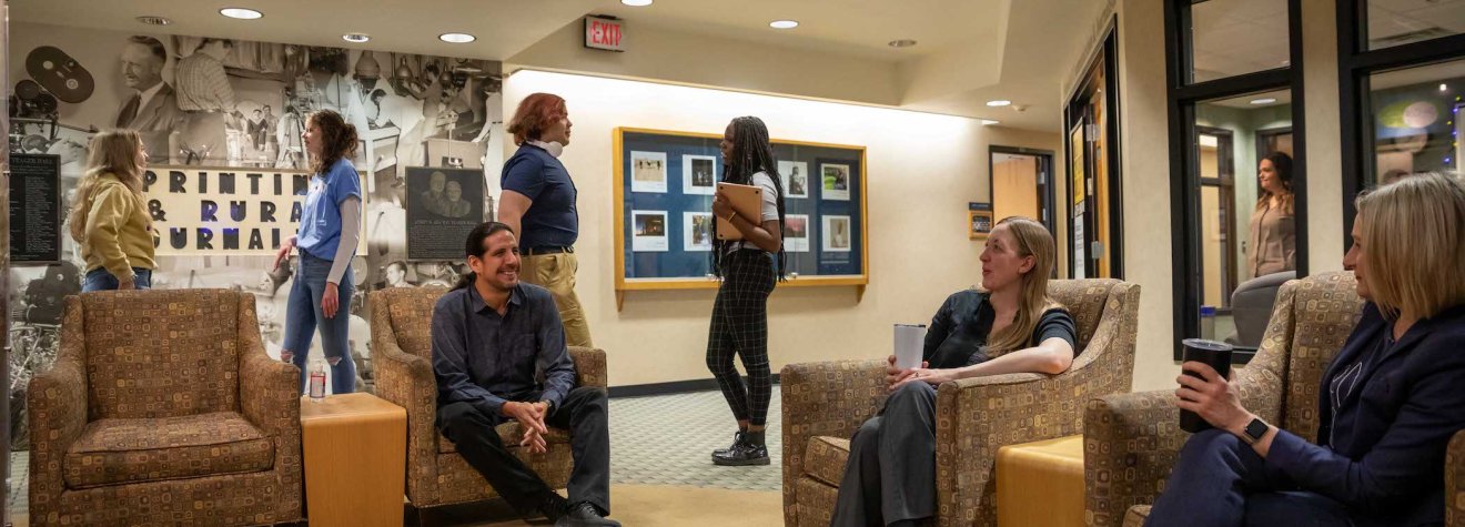 A group of people sitting in chairs talking.