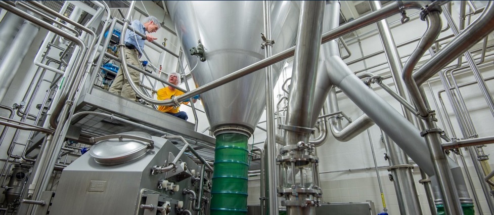 View of equipment and two workers inside the Davis Dairy Plant.