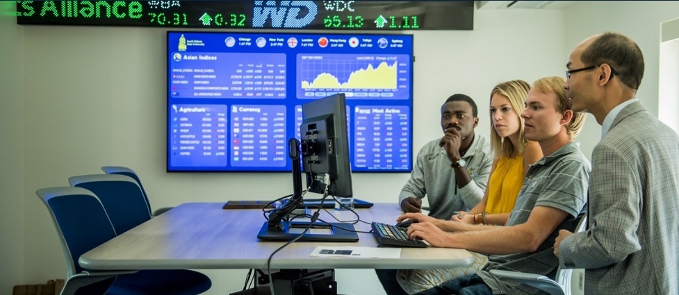 Professor and students in a finance lab.