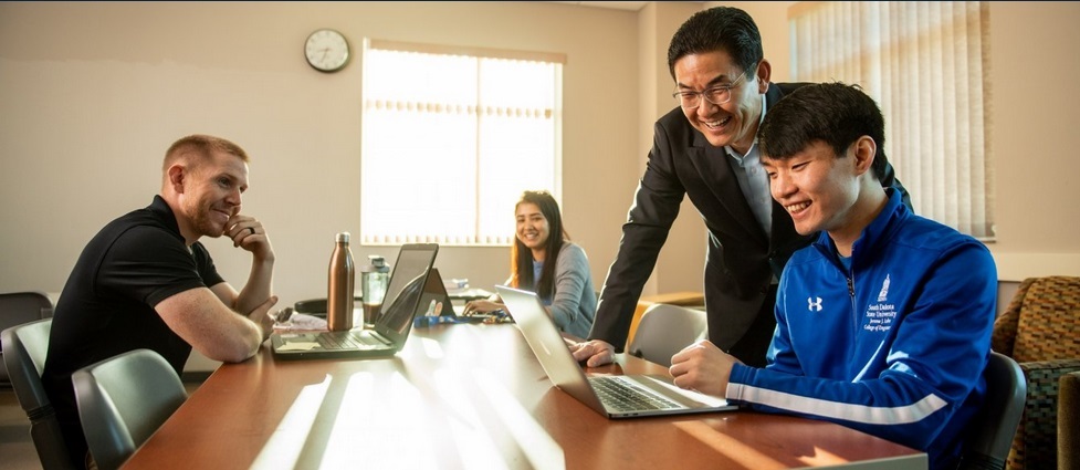 Professor talking with three students.