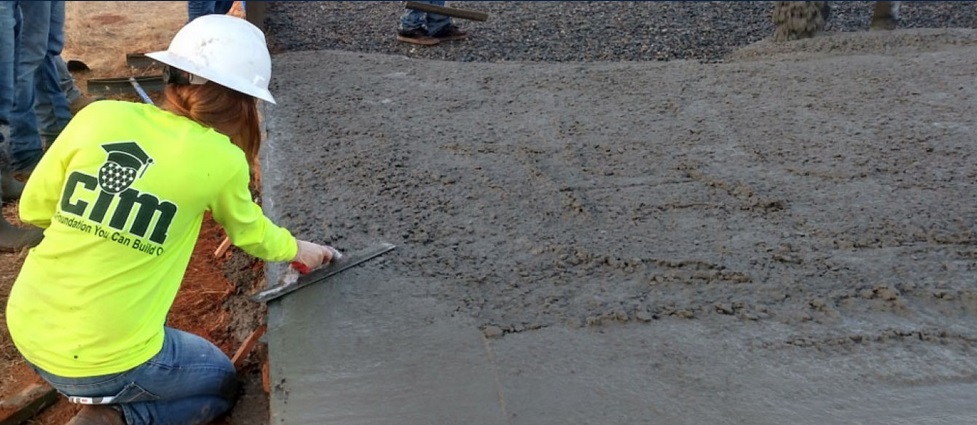 Student working with wet concrete.