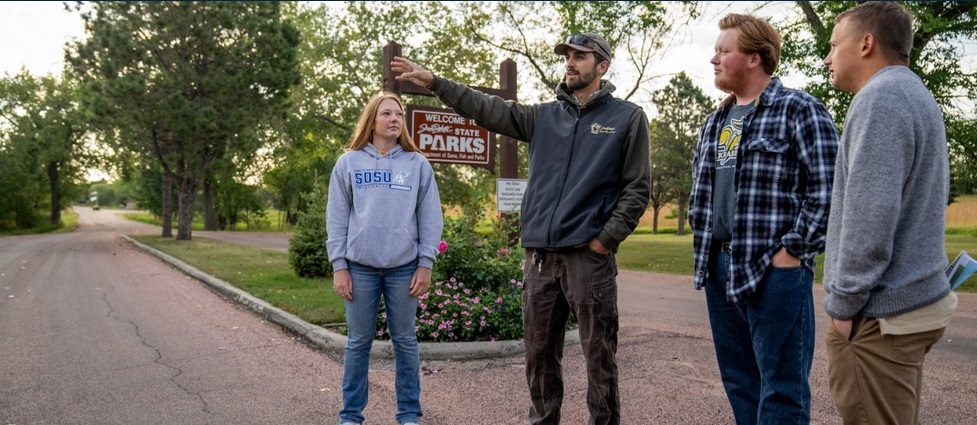 Students standing at the entrance to a state park.