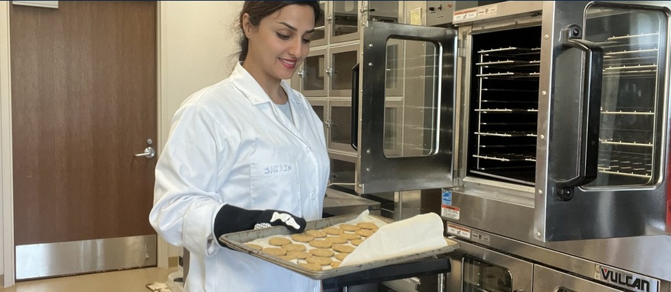 View of a student next to a computer in a lab.