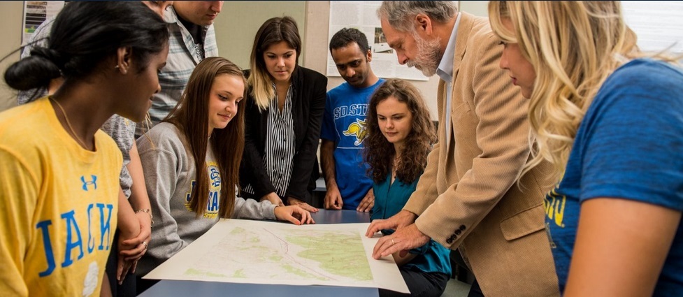 Students and instructor looking at a map.