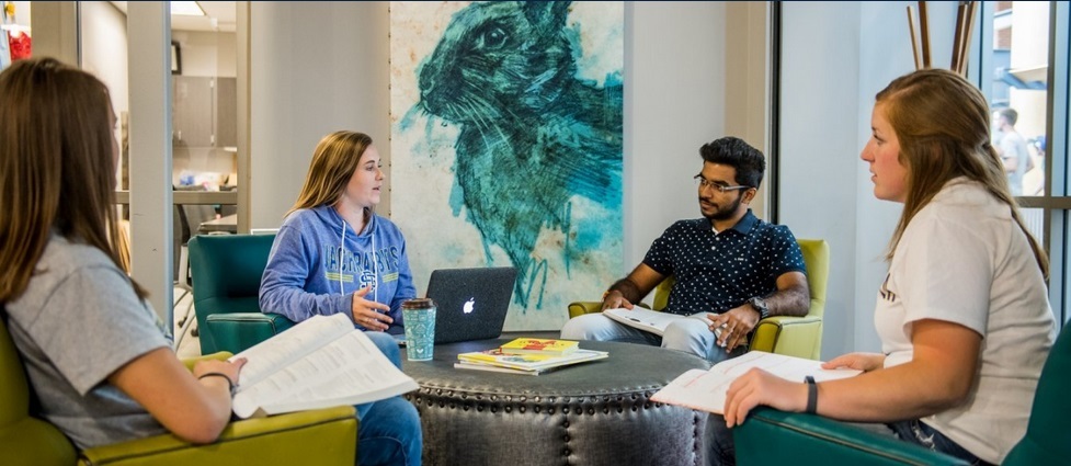 Four students sitting together talking.