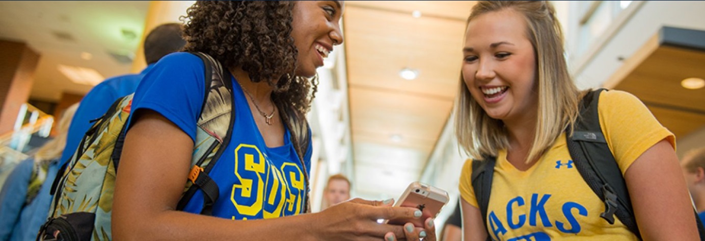 Two students looking at a phone.