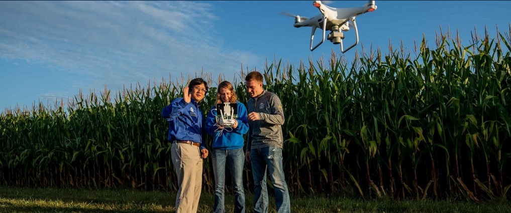 Instructor and students flying a drone.