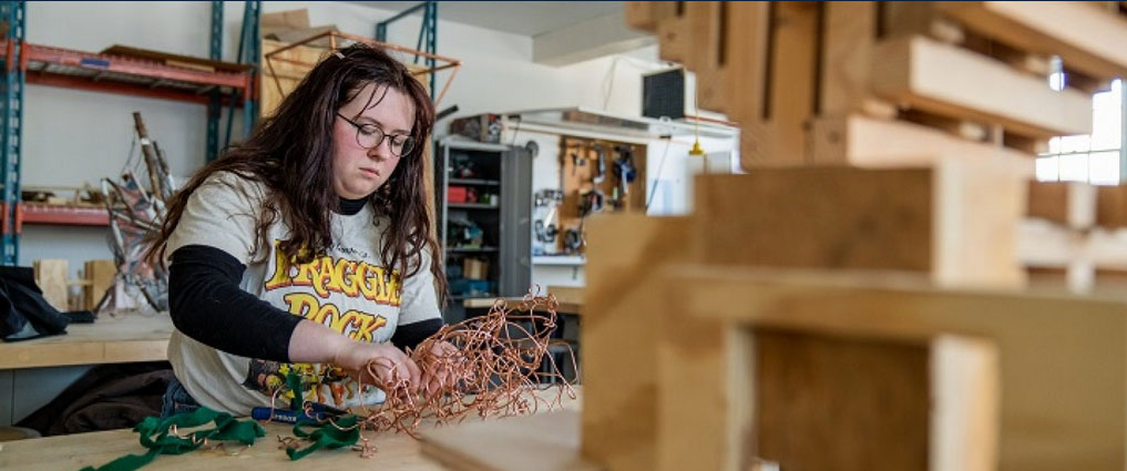 Student in studio working on a sculpture.