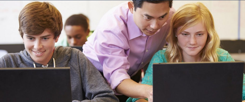 A teacher working with students in a classroom.