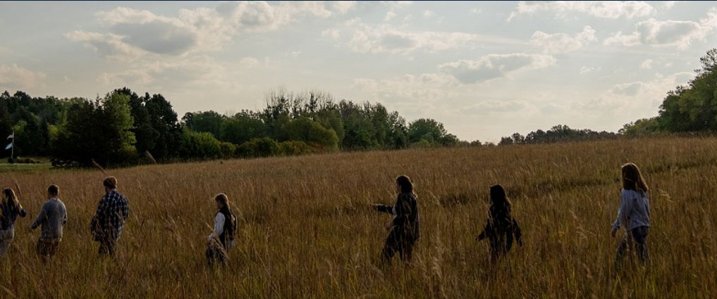 Students walking through grass.