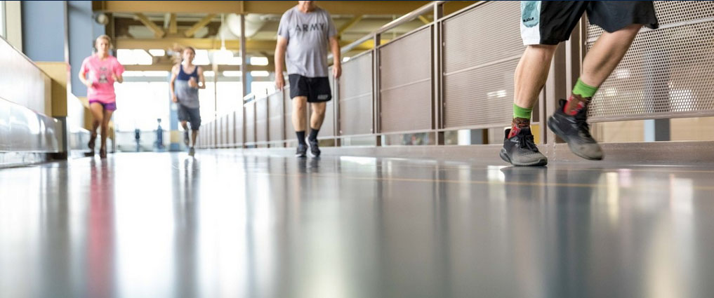 View of individuals running around an indoor track.