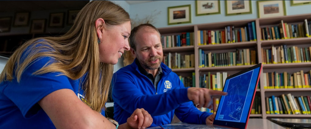 Instructor and student looking at data on a computer screen.