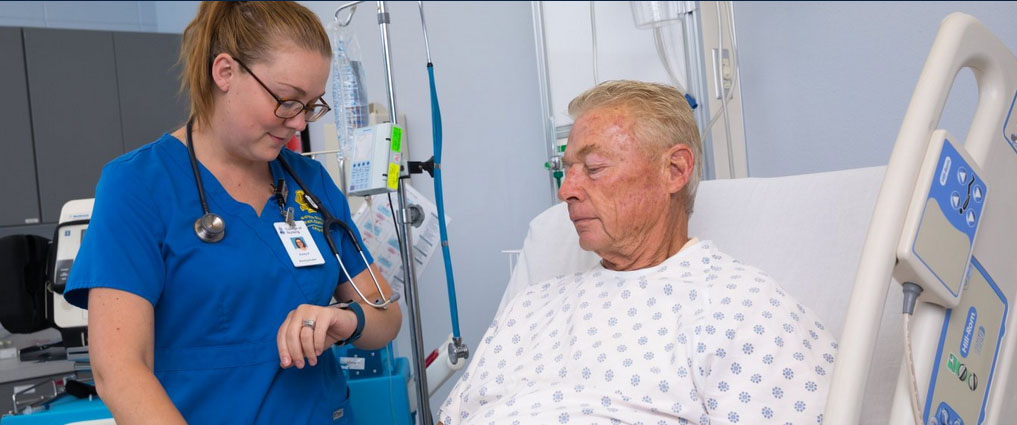 Nursing student next to a patient.