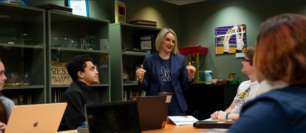 Students and faculty member in a classroom.