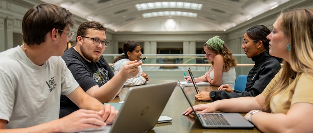 Group of students sitting at a table talking.