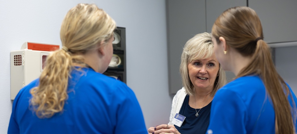 Instructor working with students in a simulation lab.