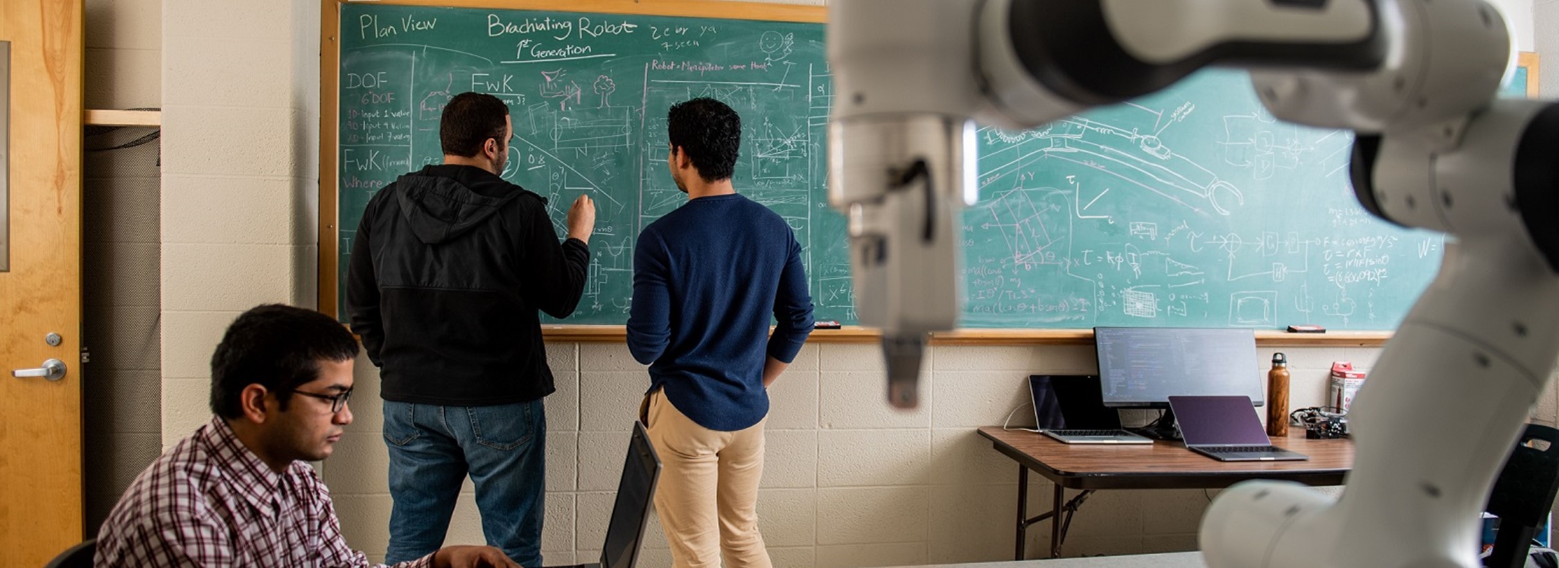 View of students writing on a chalkboard.