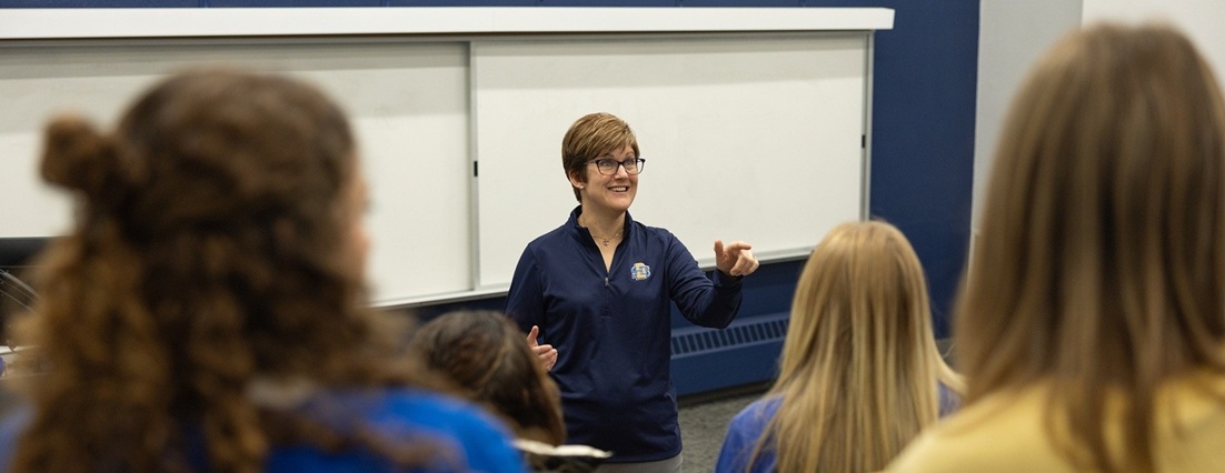 Instructor talking to a group of students in a classroom.