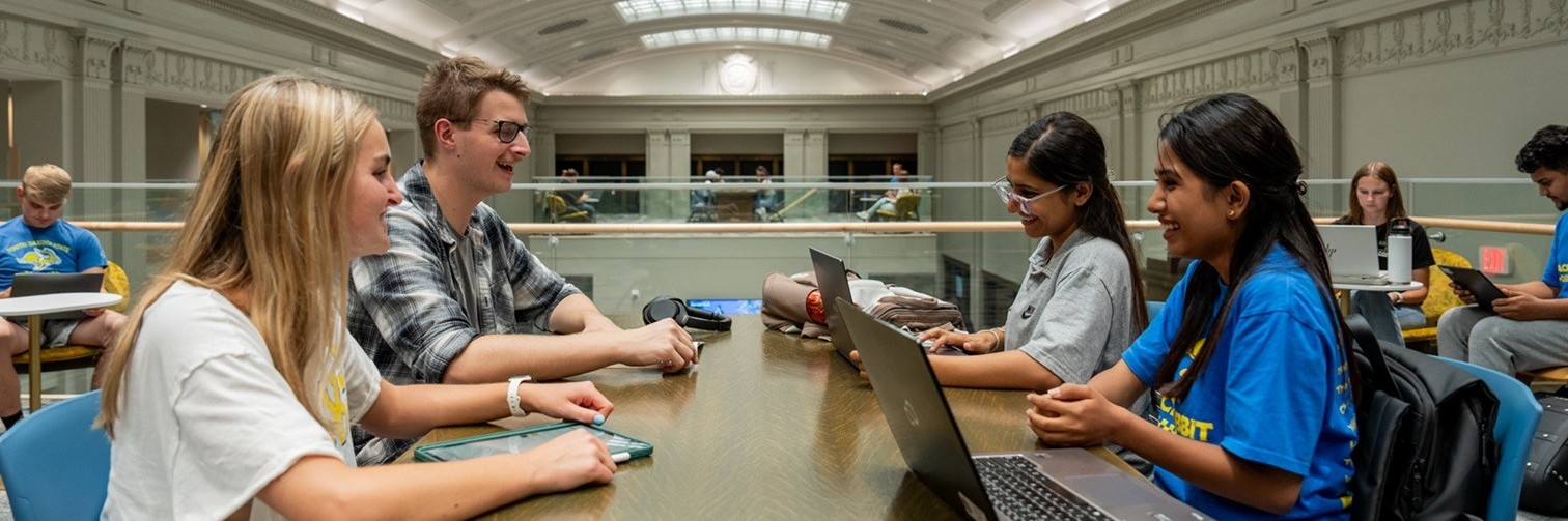 Students studying at multiple tables.